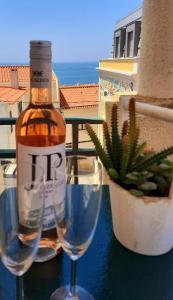 uma garrafa de álcool sentada ao lado de dois copos de vinho em Beach and Mountain Apartment Lisboa / Sesimbra em Sesimbra