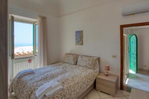 een slaapkamer met een bed en een groot raam bij House In the Tower in Amalfi