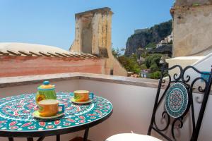 een tafel op een balkon met twee koffiekopjes bij House In the Tower in Amalfi