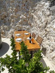 a wooden table with plates and wine glasses on a stone wall at Krka Waterfalls in Skradin
