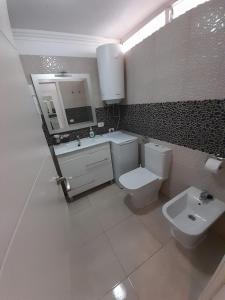 ein Badezimmer mit einem WC, einem Waschbecken und einem Spiegel in der Unterkunft Pretty View Borinquen Playa de las Americas in Playa Fañabe