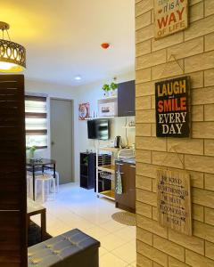 a kitchen with a wall with a sign that reads laugh smile every day at Cozy Boo Bed and Breakfast near Enchanted Kingdom by Dynel in Santa Rosa