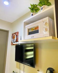 a kitchen with a microwave above a stove at Cozy Boo Bed and Breakfast near Enchanted Kingdom by Dynel in Santa Rosa