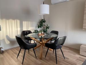 een eetkamer met een glazen tafel en zwarte stoelen bij Centrum Apartman in Kaposvár