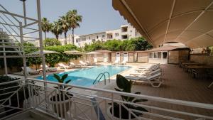 a swimming pool with chairs and umbrellas on a balcony at Arda Apart Hotel in Kemer +42 photos