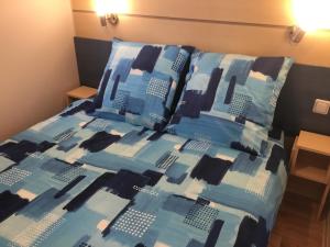 uma cama com uma colcha e almofadas azuis e pretas em Le coin tranquille em Morosaglia