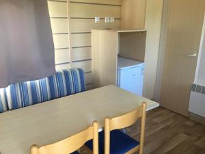 a small room with a table and a refrigerator at Le coin tranquille in Morosaglia
