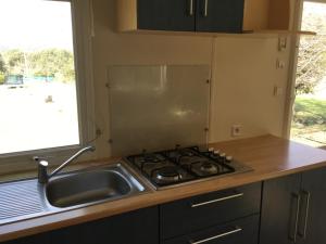 a kitchen with a stove and a sink and a window at Le coin tranquille in Morosaglia +17 photos