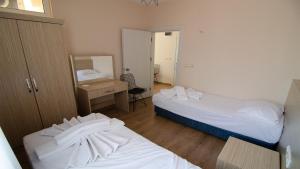 a room with two beds and a desk and a mirror at Arda Apart Hotel in Kemer
