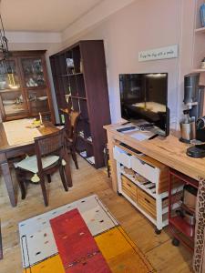 a living room with a tv and a desk with a television at Privatzimmer im Gasthaus Engel in Dornbirn