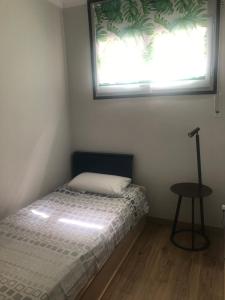 um pequeno quarto com uma cama e uma janela em SALOU al LADO de PLAYA: Bonito Apartamento, WiFi em Salou