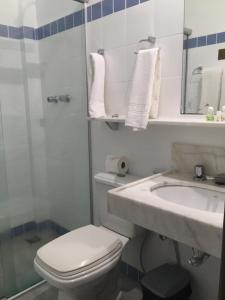 een witte badkamer met een toilet en een wastafel bij Pousada Dos Ofícios in Ouro Preto