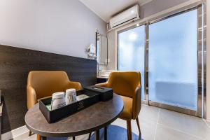 a room with a table and chairs and a window at Hotel the Rest in Cheongju