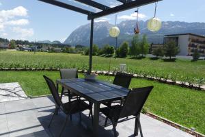 einen Tisch und Stühle auf einer Terrasse mit Blick auf ein Feld in der Unterkunft Alpenlodge Bad Mitterndorf in Bad Mitterndorf