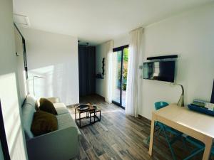 a living room with a couch and a table at Le petit Mazet du Domaine avec sa piscine in Saint-Rémy-de-Provence