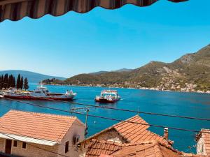 three boats are docked in a large body of water at Apartments Vučinović in Tivat