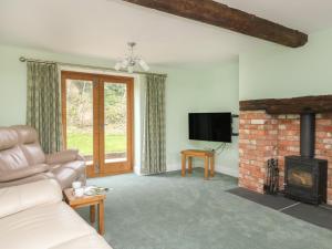 a living room with a couch and a fireplace at The Granary, Burton Bradstock in Bridport