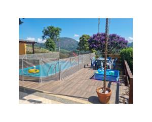 um deque com uma piscina com uma mesa e uma piscina em Temporada no Paraíso em Teresópolis em Teresópolis