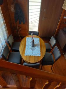 a wooden table with chairs and a vase on it at Log Cabin in Strezovce in Kumanovo