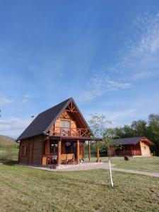 uma grande cabana de madeira num campo ao lado de um campo em Log Cabin in Strezovce em Kumanovo