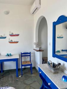 a bathroom with a mirror and a blue chair and a sink at Cavos Studio by the sea (North) in Drios +21 photos