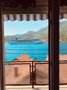 une vue sur un navire de croisière dans l'eau depuis une fenêtre dans l'établissement Apartments Vučinović, à Tivat