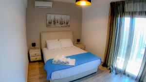 a small bedroom with a bed and a window at ANTONY's LUXURY APARTMENTS in Nikiti