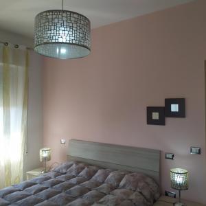 a bedroom with a large bed and a chandelier at Terrazza sul Mare in Giulianova