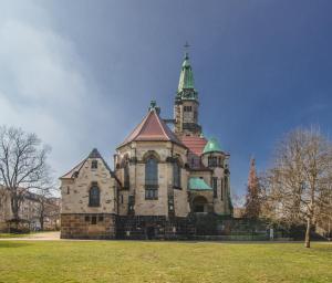 um edifício antigo com uma torre num campo de relva em Zentral Smart Apartment em Zwickau