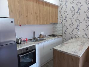 a kitchen with a sink and a refrigerator at The Yellow Brick Apartment in Tbilisi City