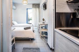 Habitación de hotel con 2 camas y lavamanos en Ninetta's Studios, en Poros