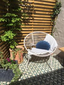 einen weißen Stuhl mit einem blauen Kissen auf einer Terrasse in der Unterkunft Shoemakers Cottage in Ramsgate