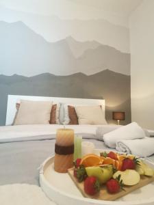 a tray of fruit on a table in front of a bed at King's Cave in Jajce