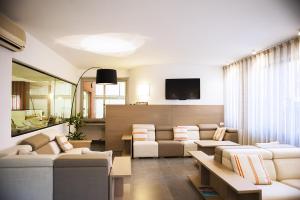 a living room with couches and a flat screen tv at Hotel Palme in Monterosso al Mare