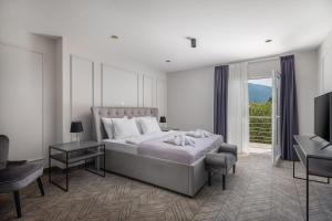 a bedroom with a bed and a desk and a television at Zlatni Rat Beach Resort in Bol