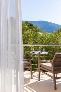 a patio with a table and chairs on a balcony at Zlatni Rat Beach Resort in Bol