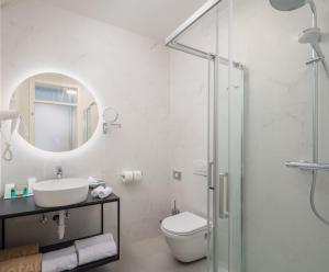 a bathroom with a toilet and a sink and a shower at Zlatni Rat Beach Resort in Bol