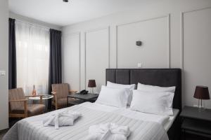 a bedroom with a large white bed with towels on it at Zlatni Rat Beach Resort in Bol