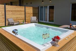 a bath tub with two glasses of wine in it at Zlatni Rat Beach Resort in Bol