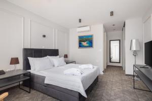 a bedroom with a large bed with white sheets at Zlatni Rat Beach Resort in Bol