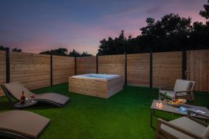 a backyard with a fence and a hot tub at Zlatni Rat Beach Resort in Bol