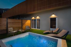 a hot tub in a backyard with chairs and tables at Zlatni Rat Beach Resort in Bol