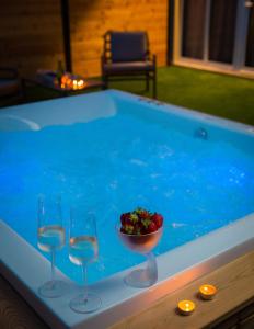 three wine glasses and a bowl of strawberries in a pool at Zlatni Rat Beach Resort in Bol