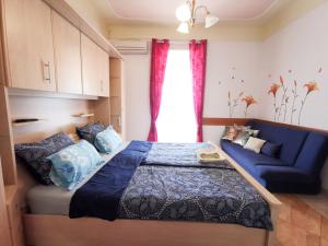 1 dormitorio con 1 cama azul y 1 sofá azul en Apartments Anita in Villa Esperia, en Opatija