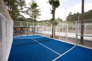 una pista de tenis con red en una pista de tenis en Camping L'Espelt en La Pobla de Lillet