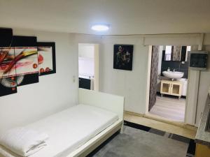 Zimmer mit einem weißen Bett und einem Waschbecken in der Unterkunft Ferienwohnung, 2 Zimmer, Küche,Bad in Staufenberg