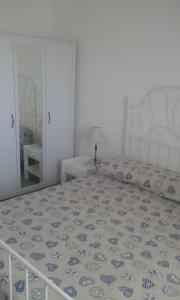 a bedroom with a large bed and a mirror at Casuzze Country in Marina di Ragusa