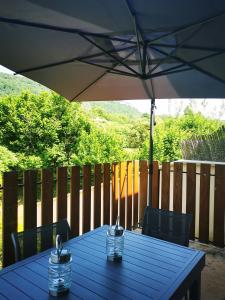 - une table bleue avec un parasol sur la terrasse dans l'établissement Au bord de Seille, à Nevy-sur-Seille