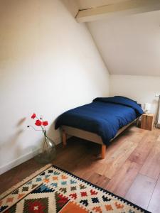 Au bord de Seille في Nevy-sur-Seille: غرفة نوم بسرير و مزهرية مع وردة