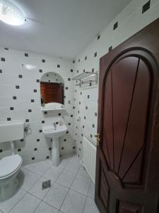 ein Badezimmer mit Toilette und Waschbecken und einer Tür in der Unterkunft Popasul Vanatorului in Poiana Sabasa + 65 Fotos